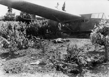 Ref: DA-01156
Crashed German glider and dead crew members, World War II, Crete. Taken by an unidentified photographer.
A photograph of a painting by Raymond McIntyre (attached to back of file print) bears a resemblance to this photograph.