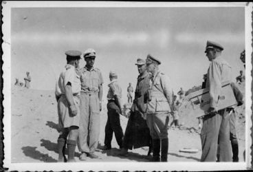 Date: Sep 1943
Ref: DA-02894B-F
Official captured film showing Brigadier George Herbert Clifton (left), after being taken as a prisoner of war, seen with General Erwin Rommel (2nd from right) and other German personnel in Egypt during World War II. Taken in September 1943 by an unidentified photographer.
Film for this image taken from a German paratrooper killed on Crete Captured Film showing Brigadier George Herbie Clifton taken P.O.W, shows General Erwin Rommel - North Africa, September, 1943