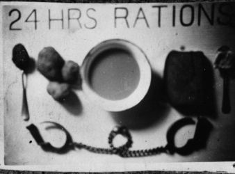 Date: 1943
Ref: DA-03225-F
This photograph brought back from Germany by a repatriated POW shows the daily food ration issued to each prisoner. It consists of three small potatoes, a small portion of watery soup, a fifth of a loaf of black bread and a spoonful of jam and margarine. The manacles shown were worn for some time by prisoners in this camp. Taken in Germany in 1943 by Corporal F A Watt. Daily Food Ration for Allied P.O.W.s - Germany, 1943