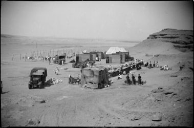 Date: 1940
Ref: DA-00530-F
General view of Maadi military camp laundry in Egypt. Laundry is collected from troops twice weekly. There is no charge for the service, which is carried out by local labour. Washing is done on bench (on R), dried on lines (L rear) and ironing and resorting of clean washing takes place in huts. Taken in 1940 by an official photographer. General View of Maadi Camp Loundry, Egypt